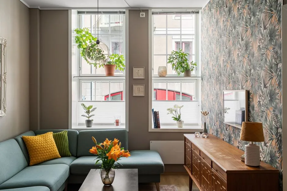 Stylish living room with abundant natural light, plants, and cozy decor.